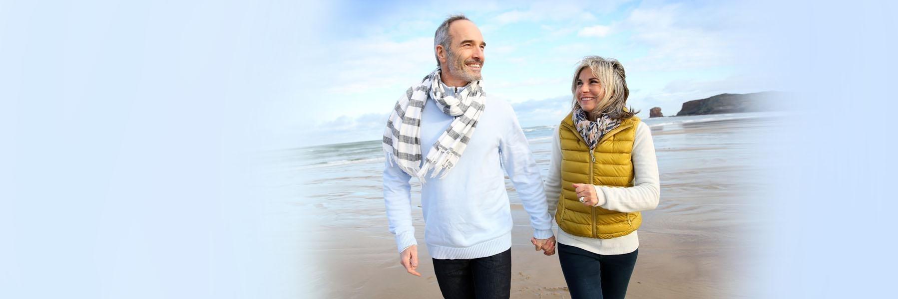 Couple holding hands and walking on the beach